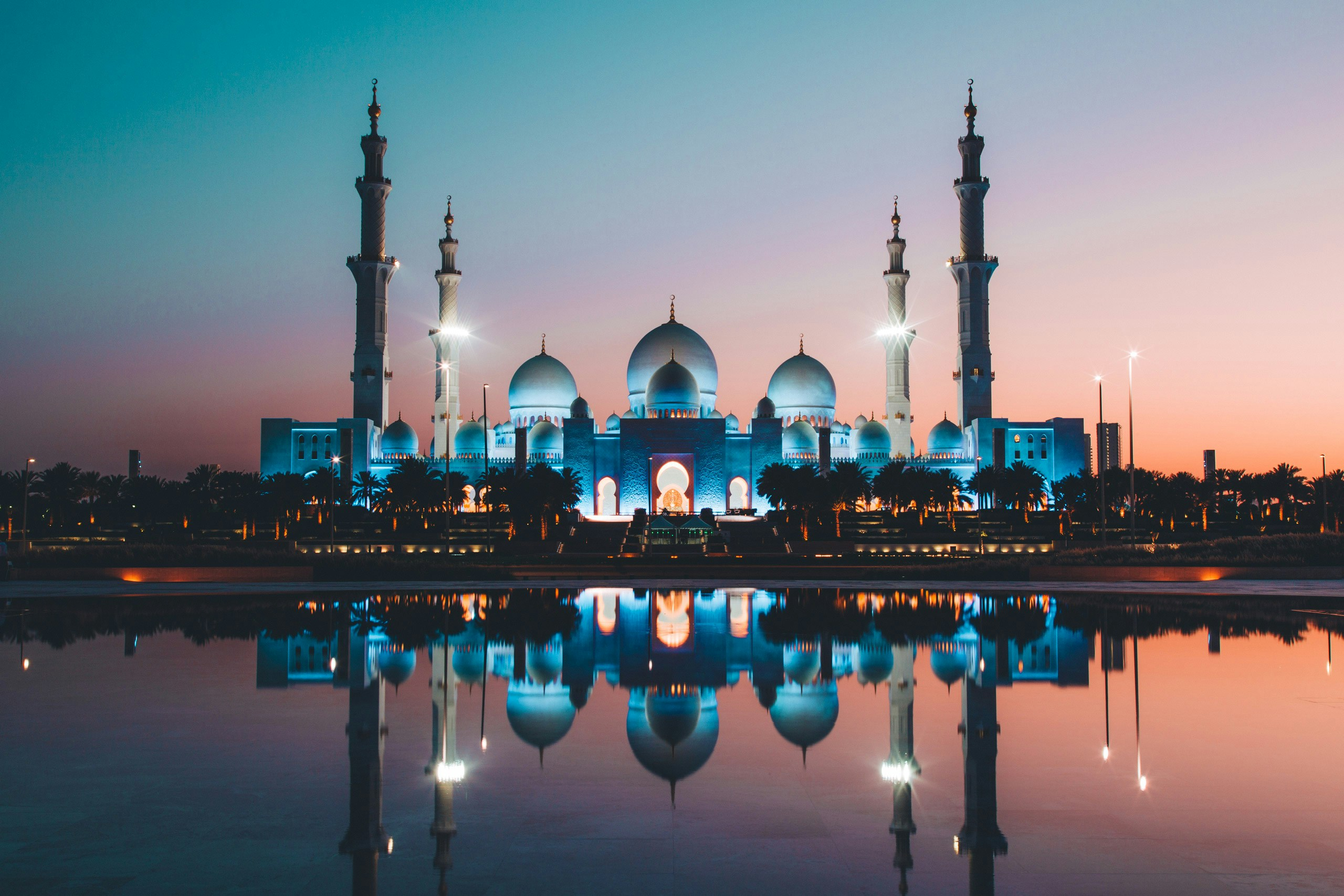 A beautiful mosque with its reflection in the water during sunset
